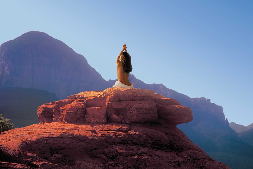 Woman Meditating on Rock